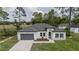 Charming single-story home features a gray garage door, white exterior, and well-maintained front yard at 6054 Sw 154Th Place Rd, Ocala, FL 34473