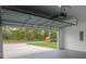 Spacious two-car garage with high ceilings, gray floor and garage door with ample lighting at 6054 Sw 154Th Place Rd, Ocala, FL 34473