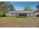 A spacious backyard featuring a screened-in patio and a view of the home's exterior and lawn at 620 Fruitwood Ave, Winter Springs, FL 32708