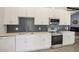 Modern kitchen with white cabinets, quartz countertops, stainless steel appliances, and unique backsplash at 620 Fruitwood Ave, Winter Springs, FL 32708