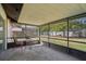 Enclosed patio featuring a metal table and chairs, offering a view of the backyard with mature trees at 620 Fruitwood Ave, Winter Springs, FL 32708