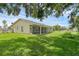 Spacious backyard with lush green lawn, screened porch, and garden bed at 715 Wedge Ln, Poinciana, FL 34759