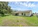Exterior shot of a fenced backyard and patio of a single-story home at 715 Wedge Ln, Poinciana, FL 34759