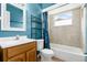 Bright bathroom with blue walls, tiled shower/tub combo, and wooden vanity at 715 Wedge Ln, Poinciana, FL 34759