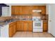 Well-lit kitchen equipped with white range, tile backsplash, and ample oak cabinetry at 715 Wedge Ln, Poinciana, FL 34759