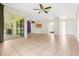 Spacious living room with tiled floor, fan, and access to both the kitchen and screened-in porch at 715 Wedge Ln, Poinciana, FL 34759