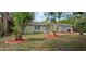 Charming single-story home features a manicured lawn with freshly mulched trees at 7600 Skyview Dr, Orlando, FL 32809