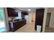 Well-lit kitchen with updated dark cabinets, neutral tile floors and backyard view at 7600 Skyview Dr, Orlando, FL 32809
