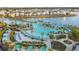 Expansive aerial view of a resort featuring a large pool, cabanas, and lush landscaping by a serene lake at 8045 Lost Shaker Ln, Kissimmee, FL 34747