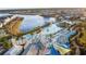 Stunning aerial view of the community pool with sandy beach, blue umbrellas, and lake at 8045 Lost Shaker Ln, Kissimmee, FL 34747