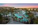 Beautiful aerial view of the resort-style pool area, cabanas, and lush tropical landscaping at sunset at 8045 Lost Shaker Ln, Kissimmee, FL 34747