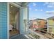 Balcony view showcasing neighboring colorful houses, complemented by a glimpse into an interior bedroom through an open door at 8045 Lost Shaker Ln, Kissimmee, FL 34747