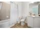 Bright bathroom featuring a shower/tub combination, toilet, and vanity with a sink, complemented by tile flooring and a white color scheme at 8045 Lost Shaker Ln, Kissimmee, FL 34747