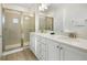 Bathroom featuring double sinks, quartz countertops, framed shower, and tile floors offering both style and functionality at 8045 Lost Shaker Ln, Kissimmee, FL 34747