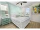 Bright bedroom featuring a queen bed, ceiling fan, light-blue accent wall, and a large window at 8045 Lost Shaker Ln, Kissimmee, FL 34747