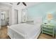 Bright bedroom boasts a white bed frame, light blue accent wall, and a walk-in closet with shelving for optimal organization at 8045 Lost Shaker Ln, Kissimmee, FL 34747