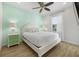 Bright bedroom with a white bed, light green accent wall, bedside table, and natural light at 8045 Lost Shaker Ln, Kissimmee, FL 34747