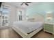 Bright bedroom featuring a queen bed, ceiling fan, light-blue accent wall, and access to a balcony at 8045 Lost Shaker Ln, Kissimmee, FL 34747
