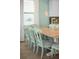 Charming dining area features a wooden table, mint-colored chairs, and natural light from the window at 8045 Lost Shaker Ln, Kissimmee, FL 34747