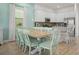 Well-lit open-concept kitchen and dining area with white cabinets, stainless steel appliances, and island seating at 8045 Lost Shaker Ln, Kissimmee, FL 34747