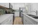 Modern kitchen featuring stainless steel appliances, white cabinets, quartz countertops, and tile backsplash at 8045 Lost Shaker Ln, Kissimmee, FL 34747