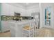 Bright kitchen with white cabinets, stainless steel appliances, tiled backsplash, and island with barstools at 8045 Lost Shaker Ln, Kissimmee, FL 34747
