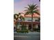 An inviting Ford's Garage restaurant featuring outdoor seating and vibrant landscaping under a colorful sunset sky at 8045 Lost Shaker Ln, Kissimmee, FL 34747