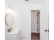 Well-lit bathroom featuring a modern vanity with gold fixtures, a decorative mirror, and a door to an adjacent area at 817 Helen Ave, Deland, FL 32720