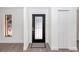 Bright entryway with sleek black front door, wood-look floors and sidelight at 817 Helen Ave, Deland, FL 32720