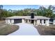 Charming single-story home with a well-manicured lawn and a long, paved driveway at 817 Helen Ave, Deland, FL 32720