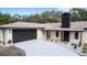 Charming home featuring a two-car garage, black trim accents, and a brick chimney at 817 Helen Ave, Deland, FL 32720