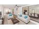 Open-concept living room with modern furnishings, ceiling fan, and a seamless flow into the dining and kitchen areas at 817 Helen Ave, Deland, FL 32720