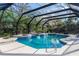 Screened-in pool area featuring a built-in spa and lush landscaping at 817 Helen Ave, Deland, FL 32720