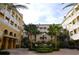 View of a courtyard area with garden and fountain surrounded by yellow buildings with balconies at 860 N Orange Ave # 371, Orlando, FL 32801