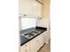Galley kitchen features a stainless steel double sink, black counter, and white cabinets at 860 N Orange Ave # 371, Orlando, FL 32801