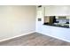 View of the living room and kitchen featuring white cabinets, black countertop and wood floors at 860 N Orange Ave # 371, Orlando, FL 32801