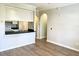 View of the living room and kitchen featuring white cabinets, black countertop and wood floors at 860 N Orange Ave # 371, Orlando, FL 32801