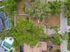 Aerial view of a house surrounded by lush trees, landscaping, pool, and a long driveway at 913 Moss Ln, Winter Park, FL 32789