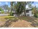Spacious backyard with a patio, lush trees, manicured lawn, and a fence at 913 Moss Ln, Winter Park, FL 32789