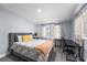 Comfortable bedroom with a gray upholstered bed, desk, and bright natural light at 913 Moss Ln, Winter Park, FL 32789
