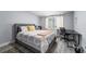 Cozy bedroom with a gray upholstered bed, desk, and bright natural light from the window at 913 Moss Ln, Winter Park, FL 32789