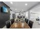 Open dining room featuring a large wood table, seating for eight, and a view into the modern, updated kitchen at 913 Moss Ln, Winter Park, FL 32789