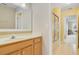 Bright bathroom with a single sink vanity, framed mirror and a view to an adjoining hallway and shower/tub at 939 Glen Abbey Cir, Winter Springs, FL 32708