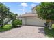 Charming single-Gathering home featuring a tile roof, brick driveway, and lush landscaping at 939 Glen Abbey Cir, Winter Springs, FL 32708