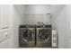 Modern laundry room equipped with a washer, dryer, and shelving for storage at 939 Glen Abbey Cir, Winter Springs, FL 32708