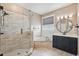Bathroom featuring a glass-enclosed shower, garden tub, and a dark vanity with a round mirror at 108 Sagecrest Dr, Ocoee, FL 34761