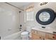 Bathroom with a tiled shower and tub, neutral walls, and a wood vanity with a round mirror at 108 Sagecrest Dr, Ocoee, FL 34761