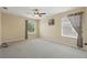 Neutral-toned room featuring soft carpeting, airy windows, and a ceiling fan, offering comfort and natural light at 108 Sagecrest Dr, Ocoee, FL 34761