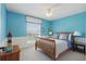 Bright bedroom with blue walls, light carpet, and a wood-framed bed by a window; modern lamps on each side at 108 Sagecrest Dr, Ocoee, FL 34761