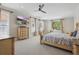 Bedroom with neutral walls, light carpet, television, and a floral bedspread on a wooden bed frame at 108 Sagecrest Dr, Ocoee, FL 34761